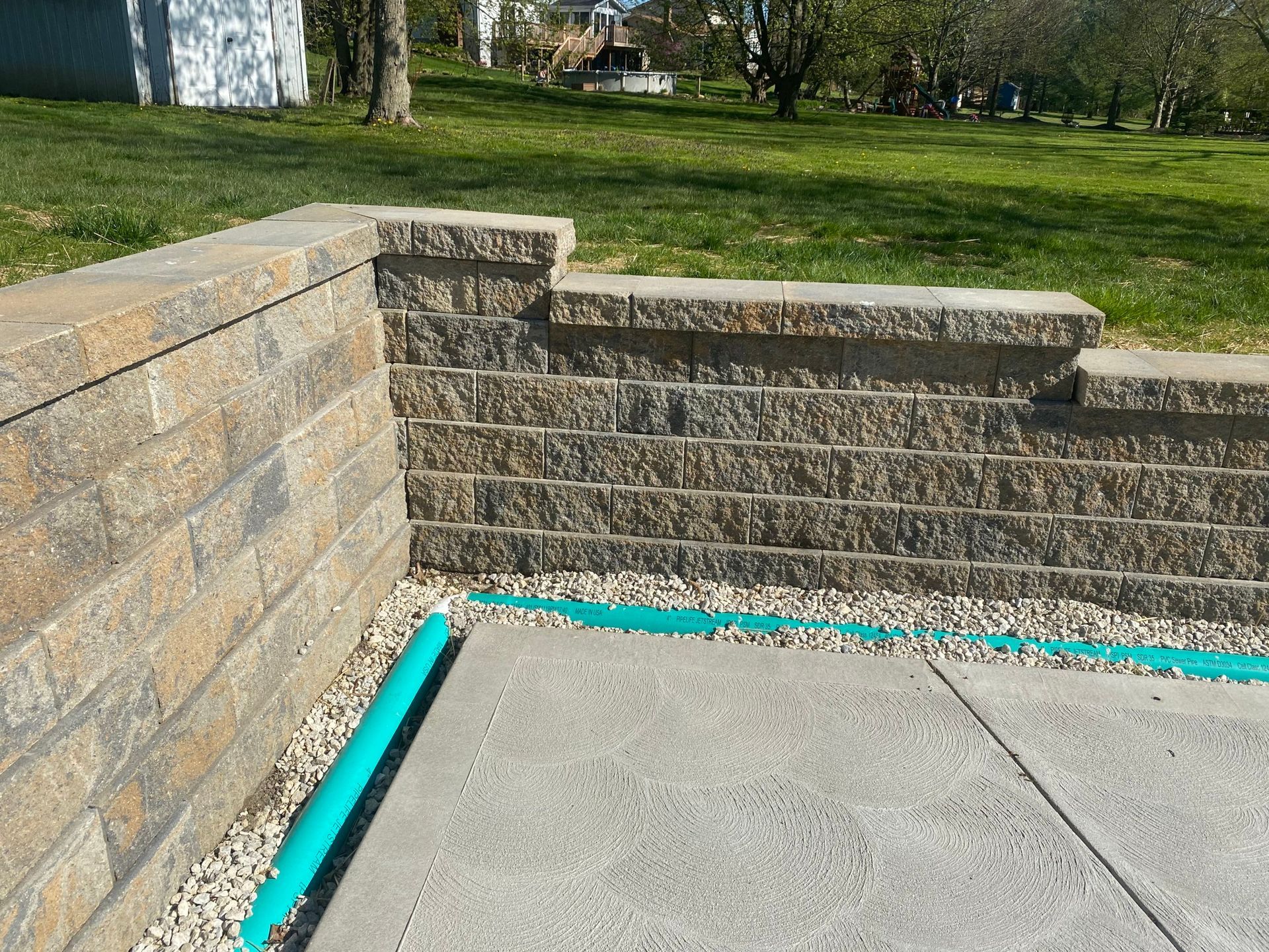 A brick wall with a blue pipe coming out of it.