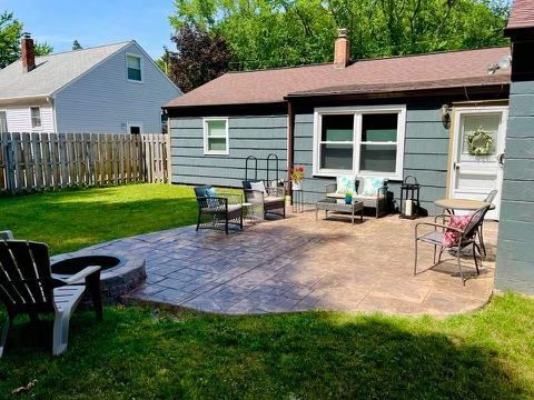There is a fire pit in the backyard of a house.
