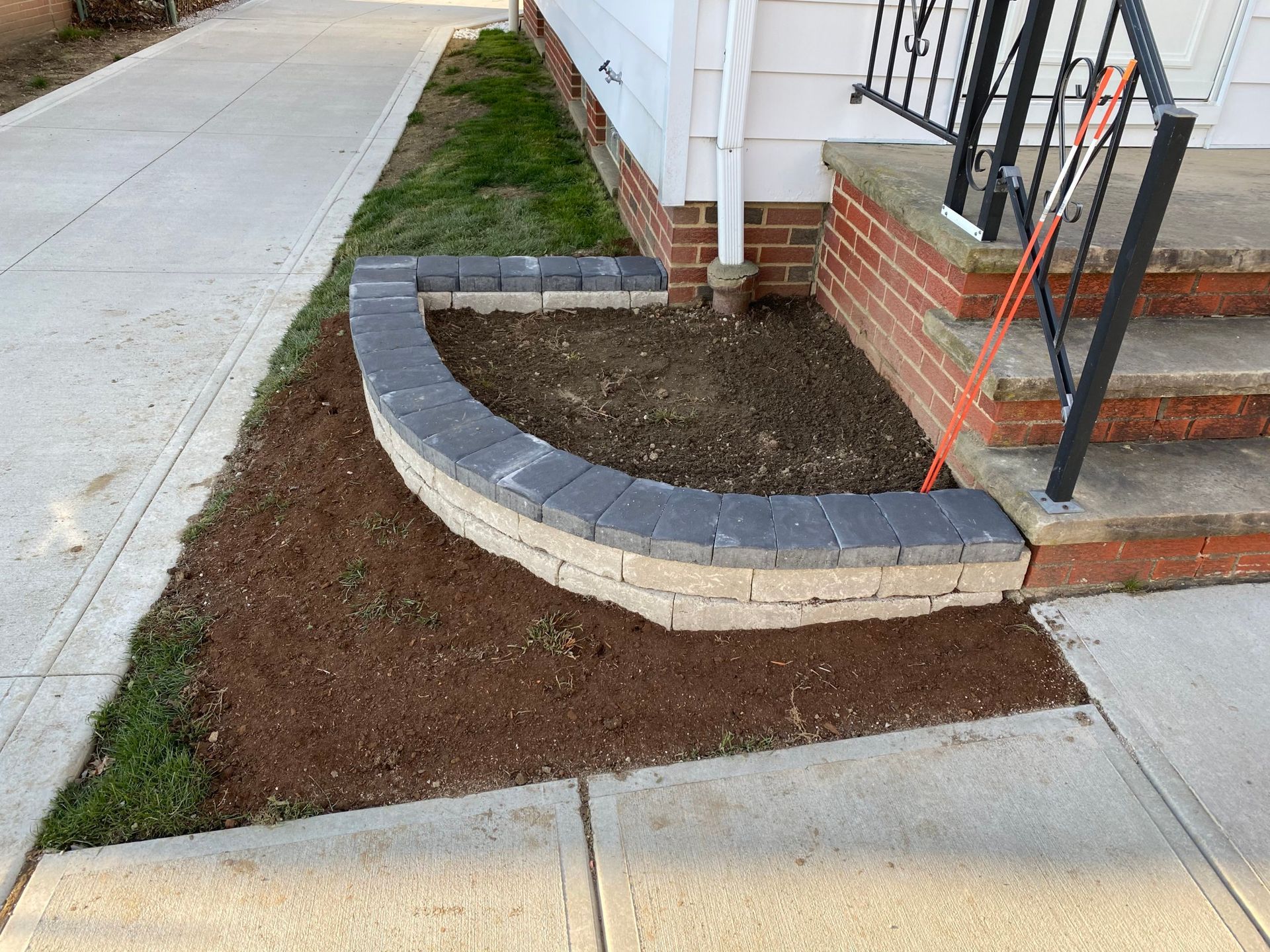 A brick wall is being built in front of a house.