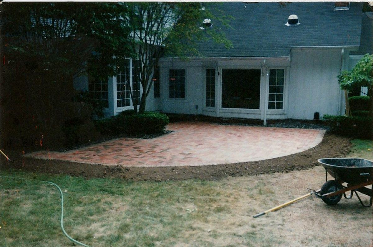 A wheelbarrow is sitting in front of a house.