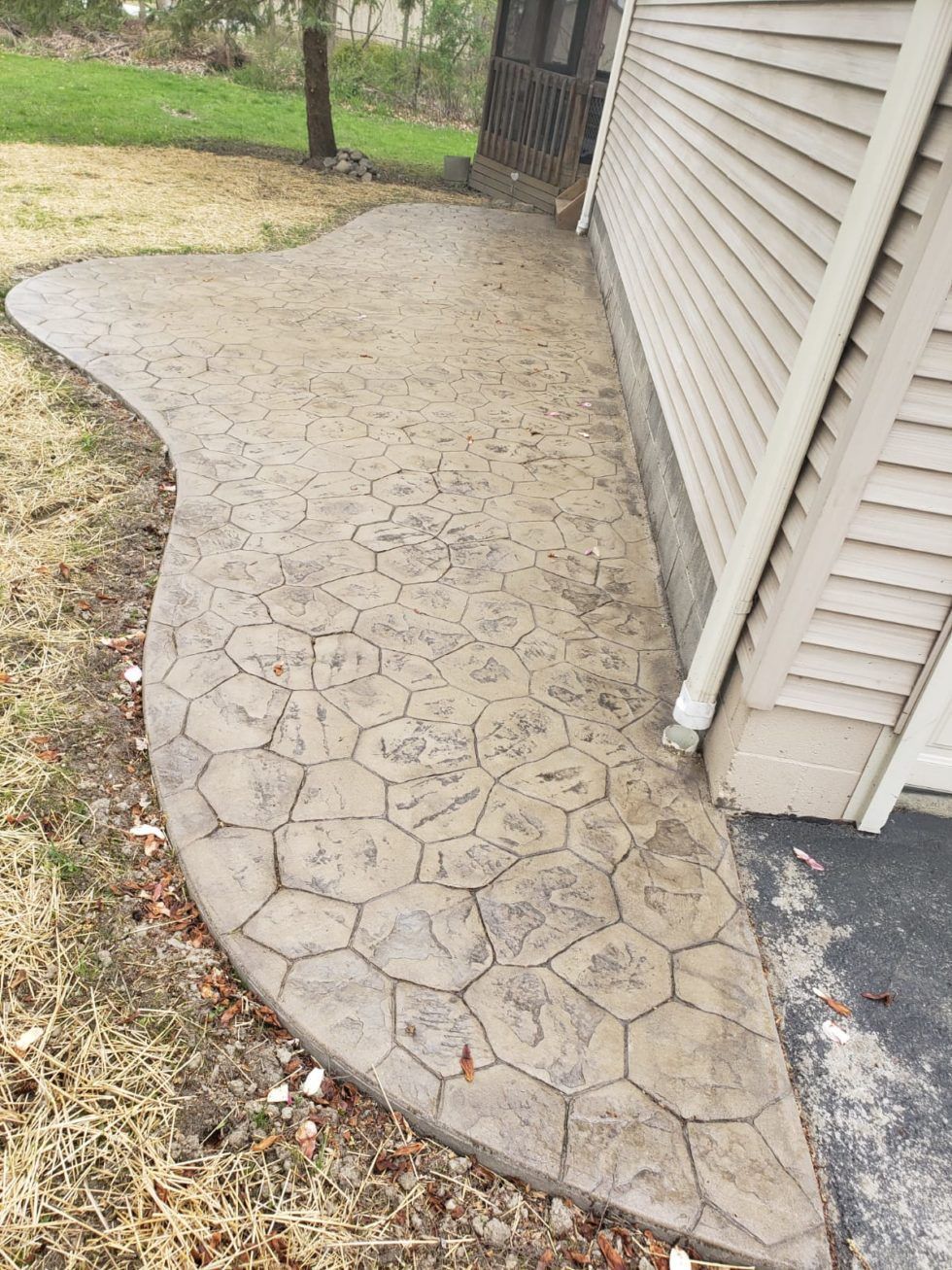 A concrete walkway leading to the side of a house.