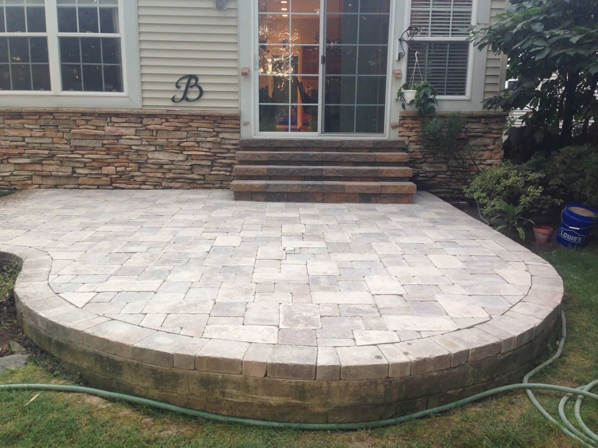 A patio with a hose attached to it in front of a house.