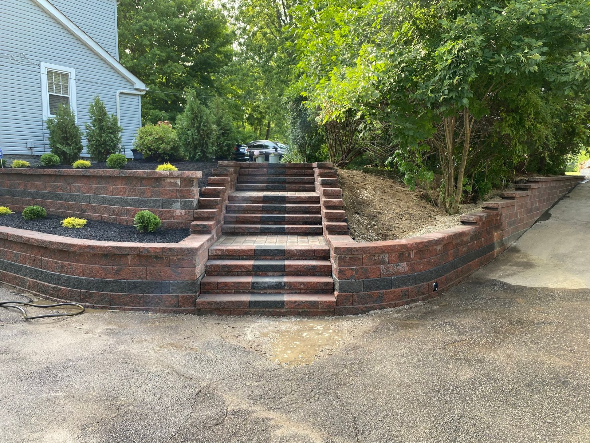 A brick wall with stairs leading up to a house.