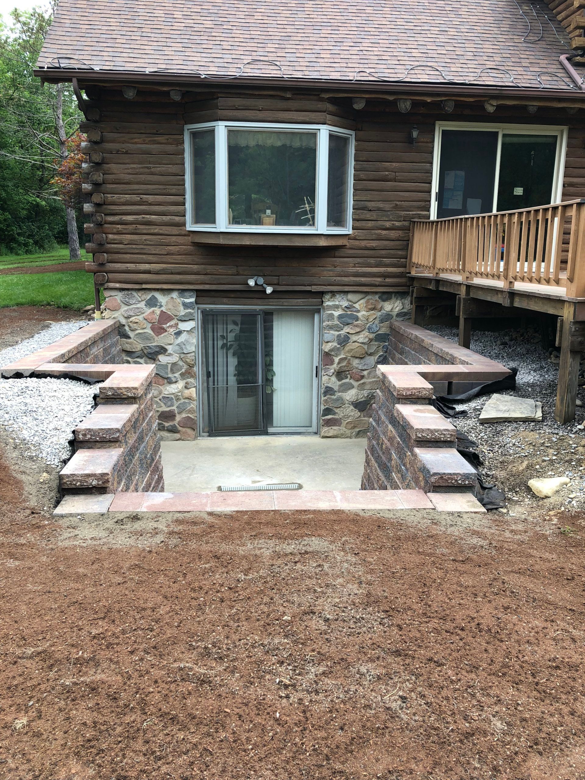 A log cabin with stairs leading up to it and a deck.