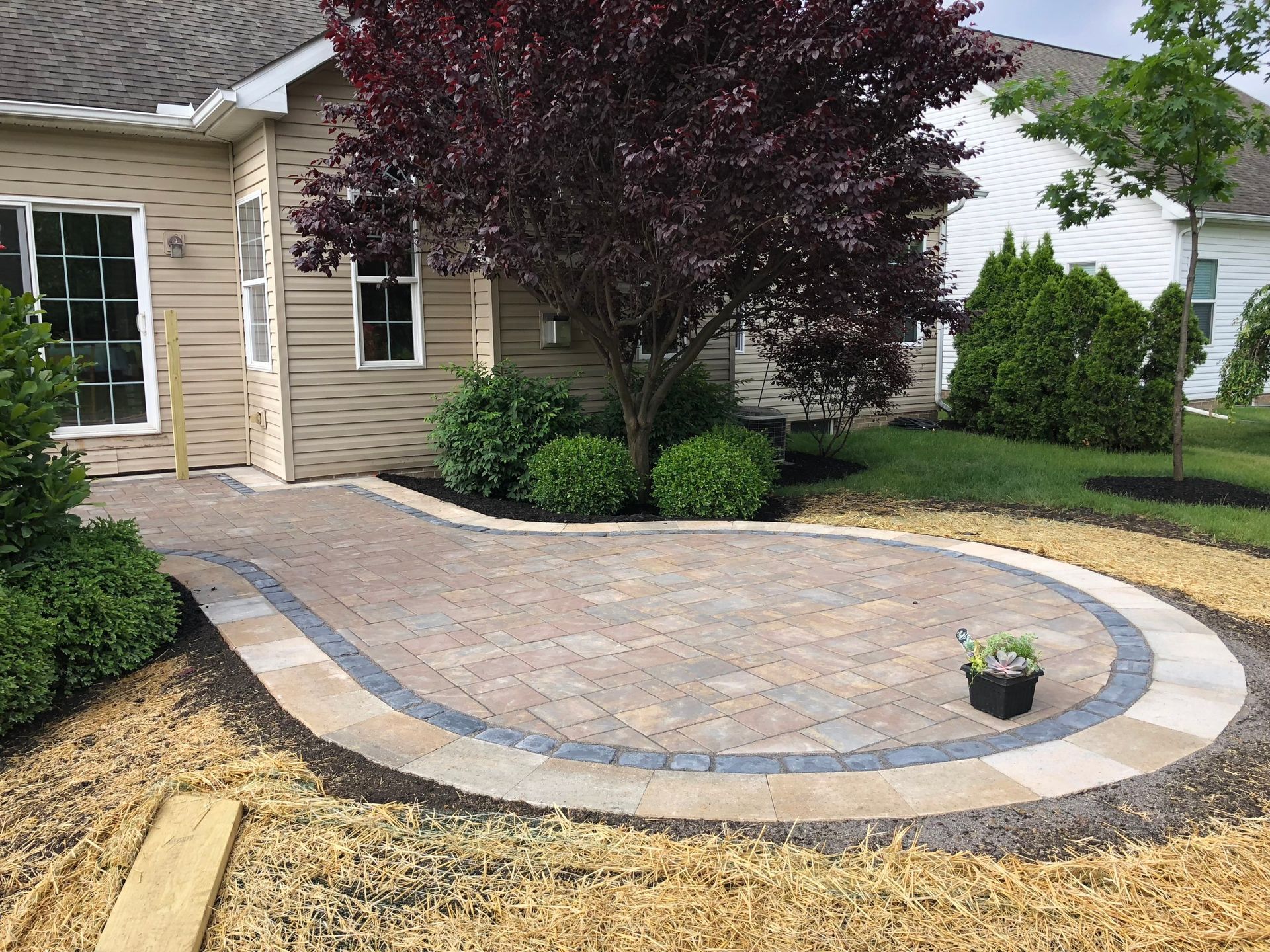 A brick walkway is being built in front of a house.