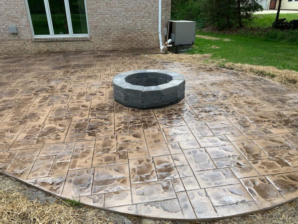 A fire pit is sitting on top of a concrete patio.
