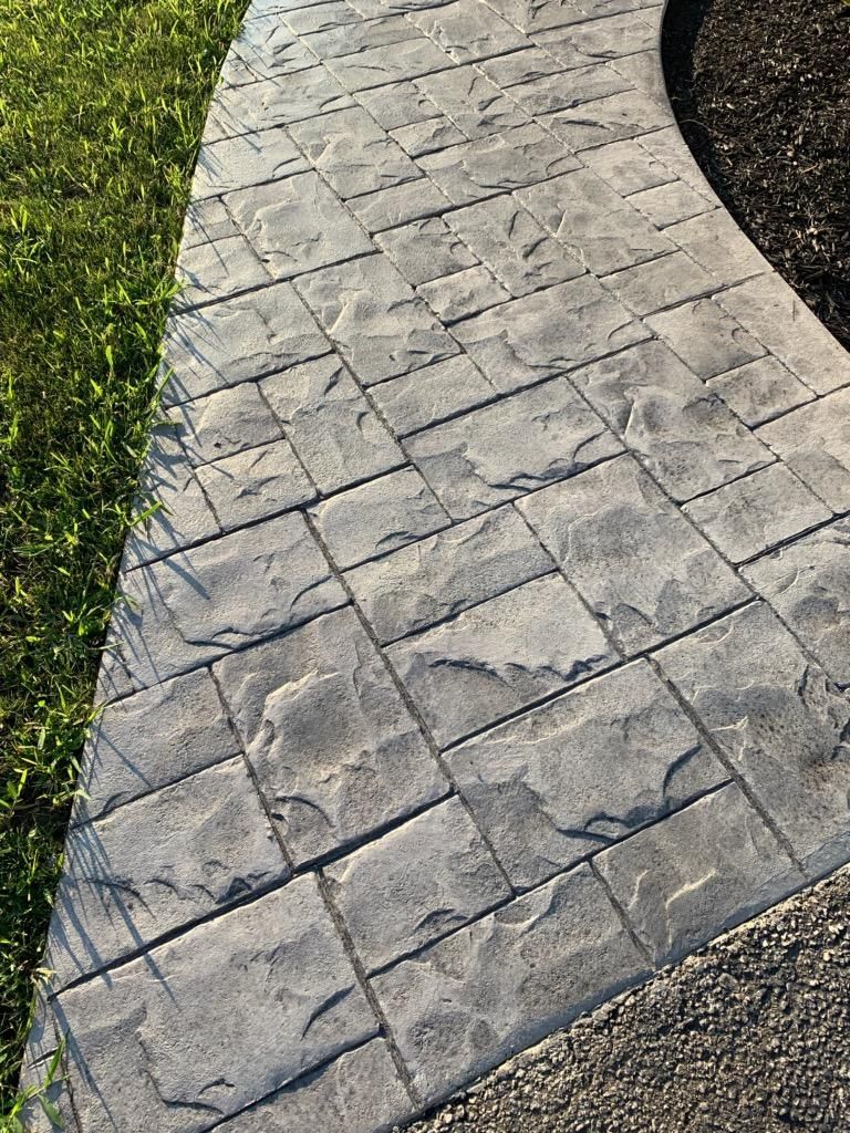 A close up of a concrete walkway next to a grassy area.