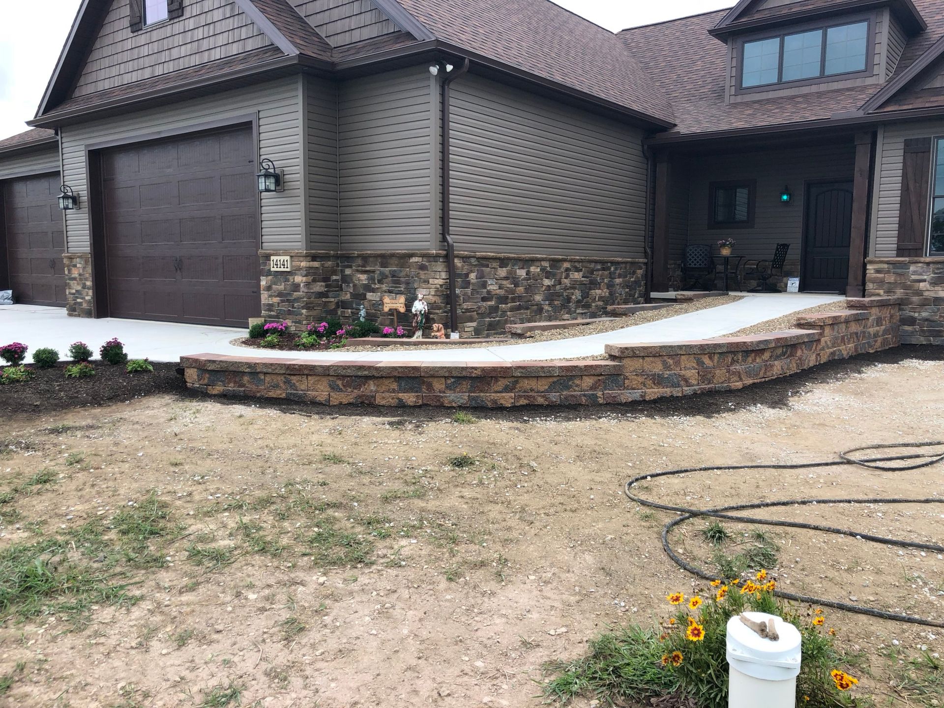 A large house with a stone wall in front of it.