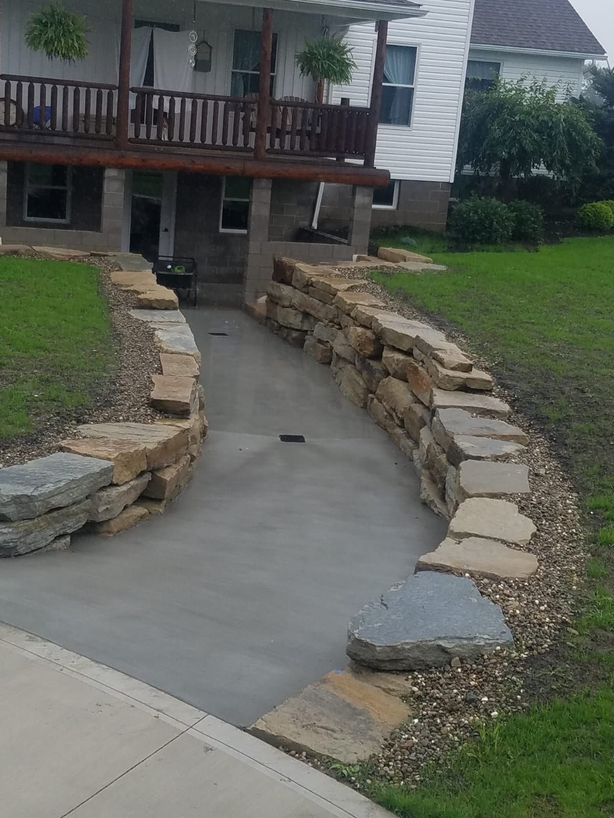 A stone walkway leading to a house with a porch