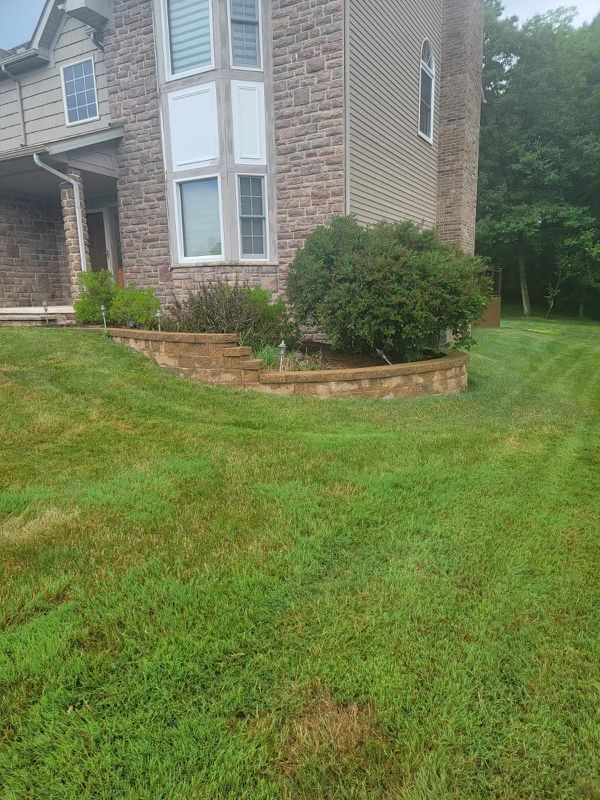 A large brick house with a lush green lawn in front of it.