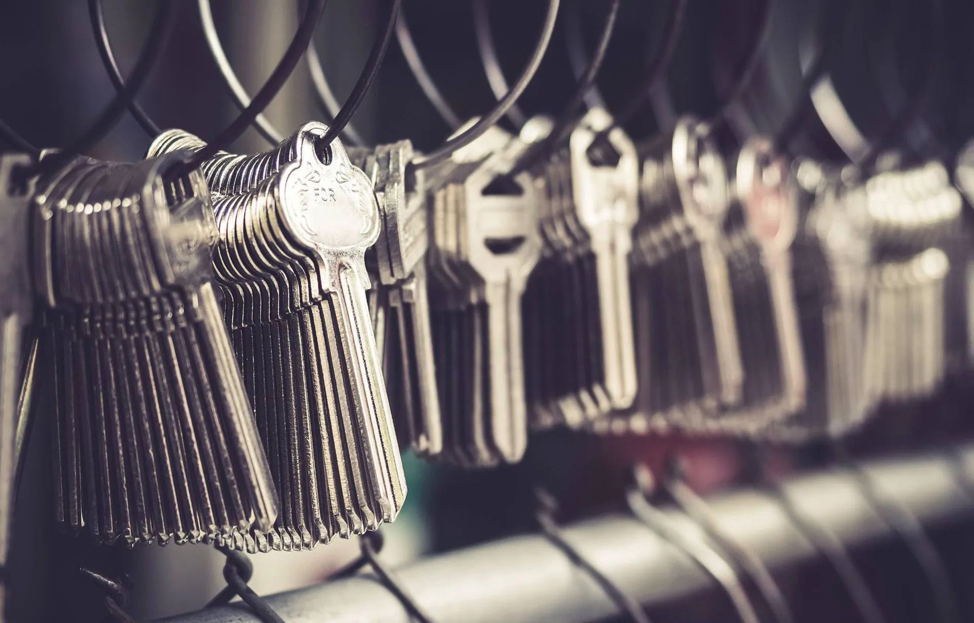 Keys hanging on hooks in a row, close-up with a slightly blurred background.