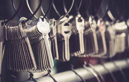 Keys hanging on hooks in a row, close-up with a slightly blurred background.