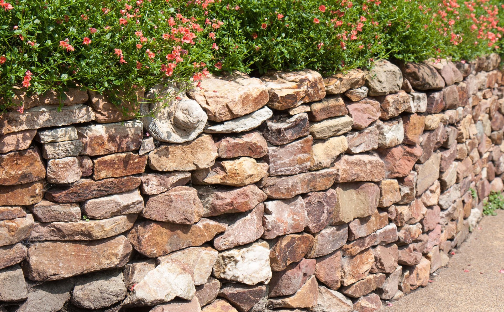 Workers in neon vests and hard hats feed tree limbs into a wood chipper truck on a street.