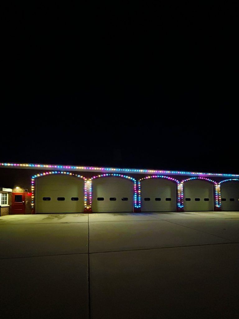 Garage with arches outlined in colorful holiday lights at night