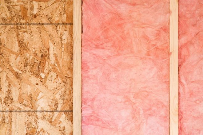 Interior wall under construction showing plywood and pink insulation.