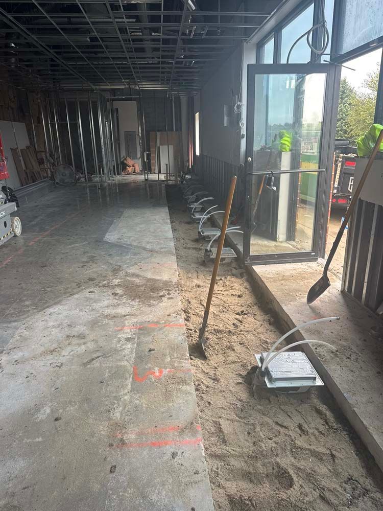 Construction site: interior space with unfinished walls, dirt floor, and a partially open door.