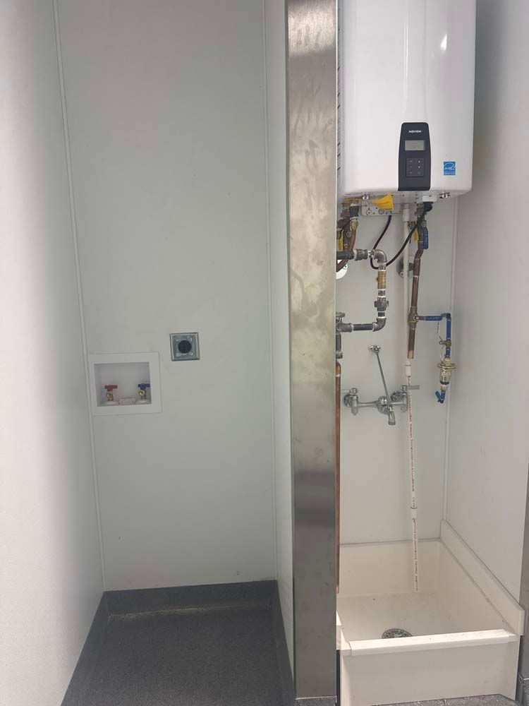 Laundry room with water heater, washing machine hookups, and a utility sink.