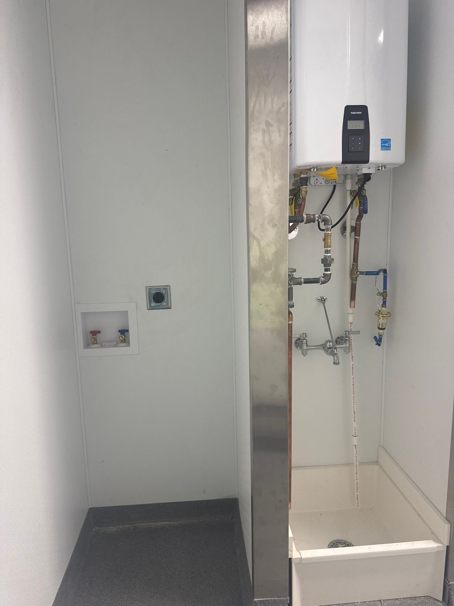 Small utility room with a water heater, laundry hookups, and a utility sink.