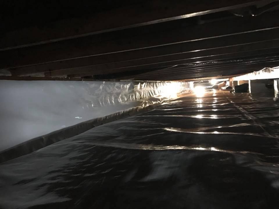 A dark room with a light shining through the ceiling