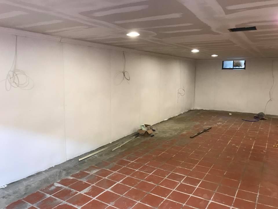 A room with white walls and a red tile floor.