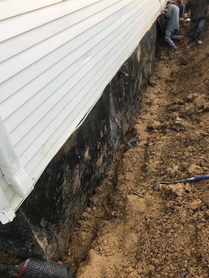 A group of people are working on the side of a house.