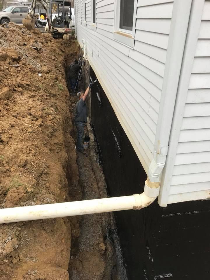 A man is working on the side of a house.
