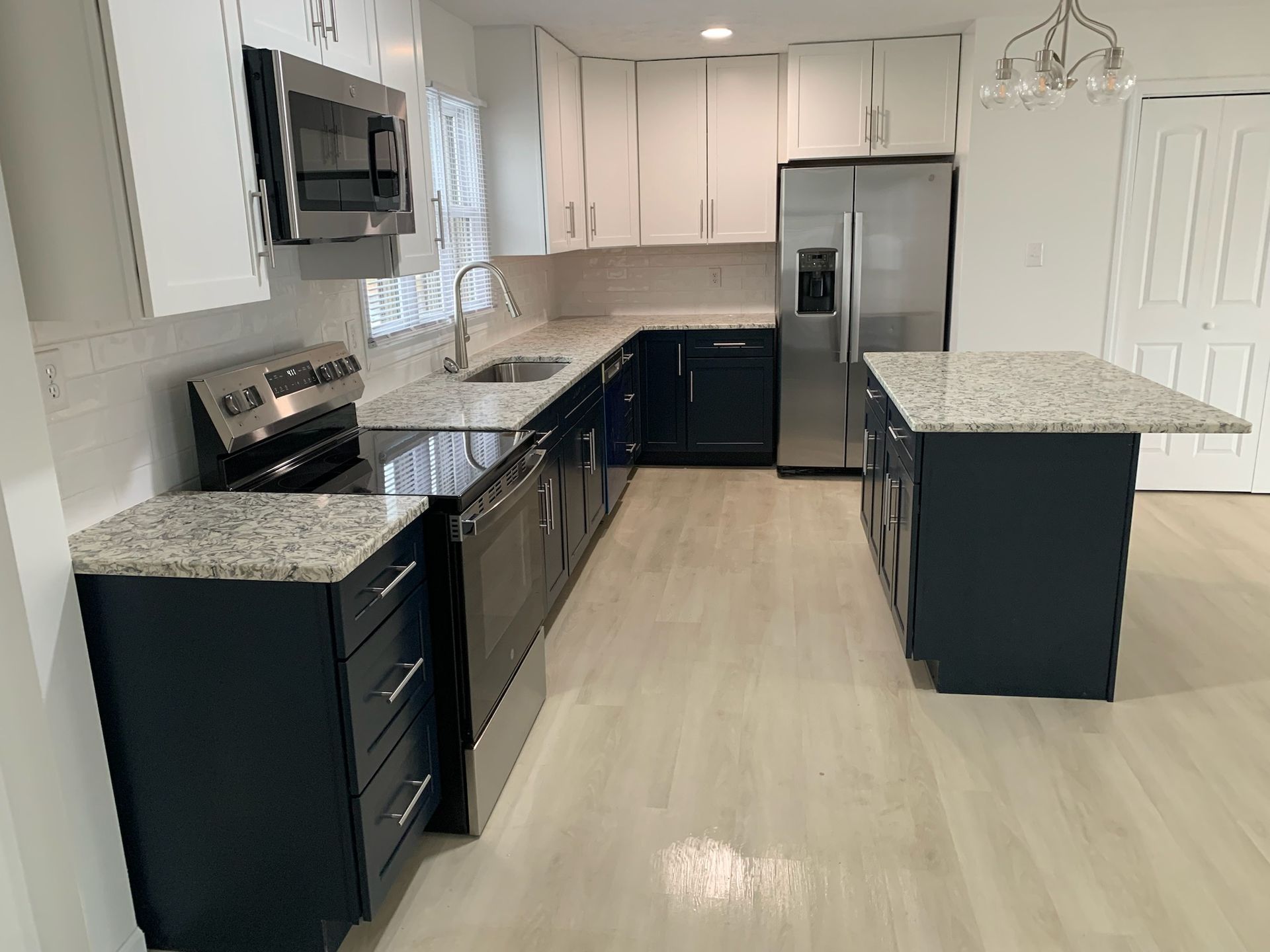 A kitchen with stainless steel appliances and granite counter tops.