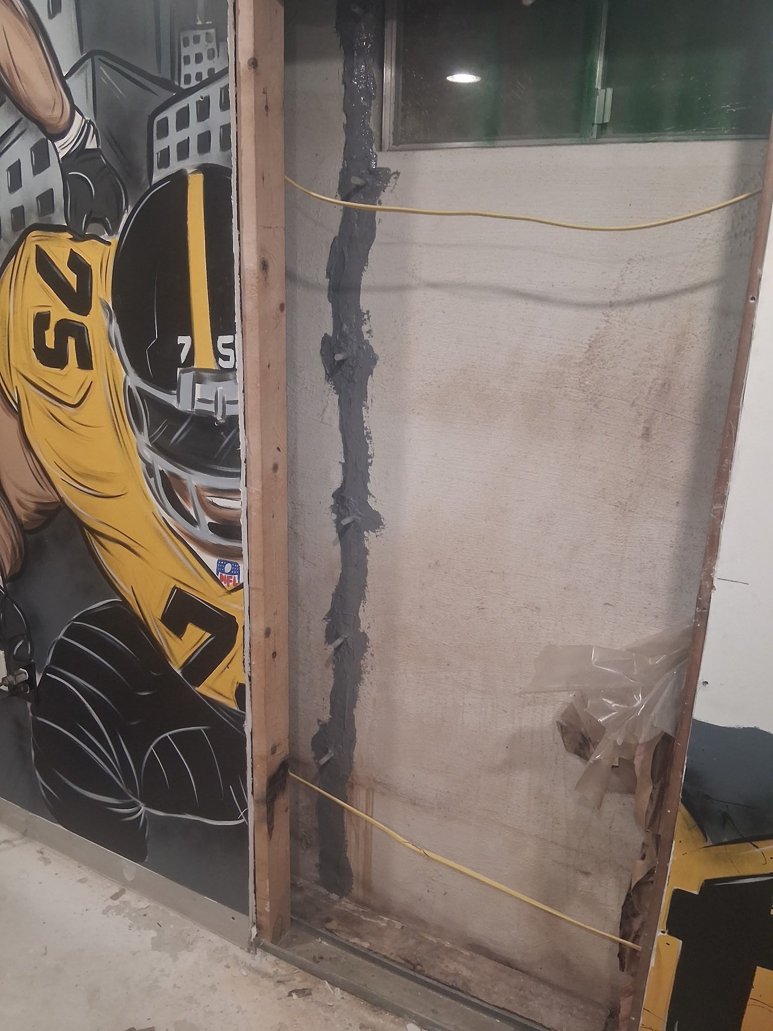 Yellow race car graphic behind a dusty glass door frame