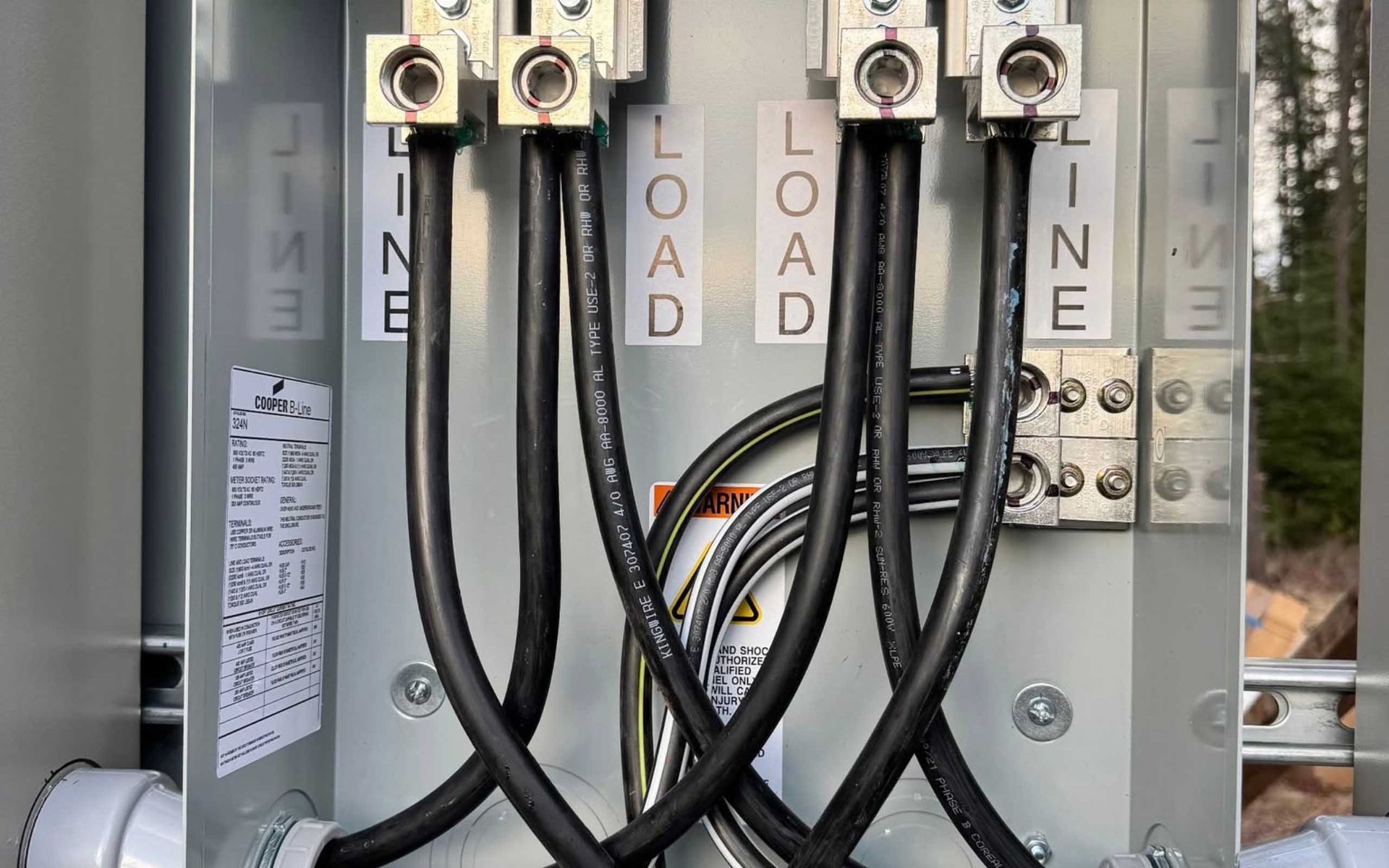 Electrical panel with black wires labeled 