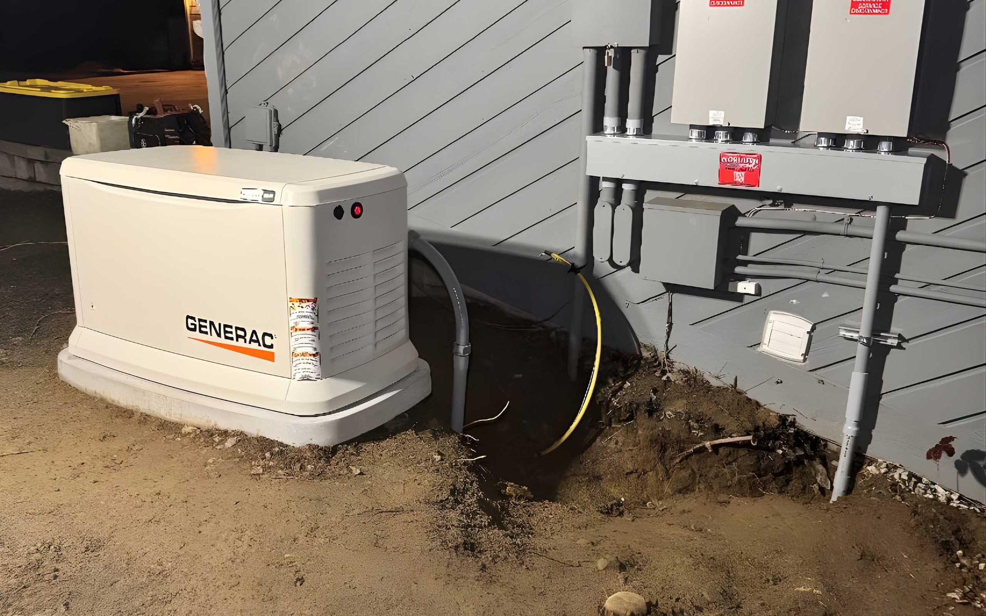 Generac generator next to a building, connected by conduit. Concrete pad.
