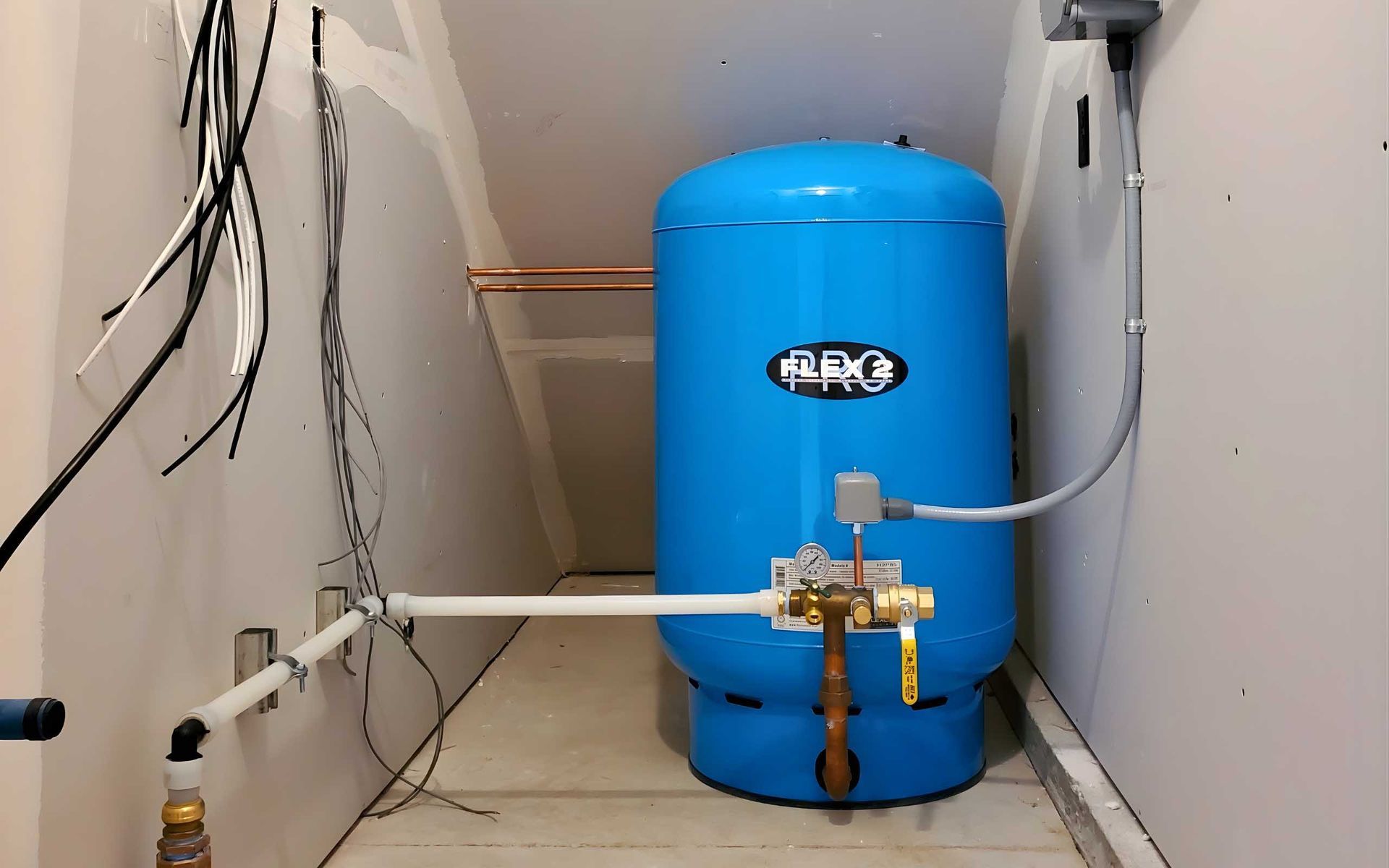 Blue water pressure tank in a utility room with pipes and wiring.
