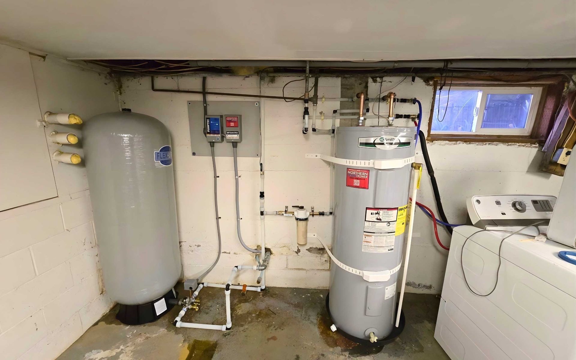 Basement water systems: tank, heater, pipes, electrical box, laundry machine, window.