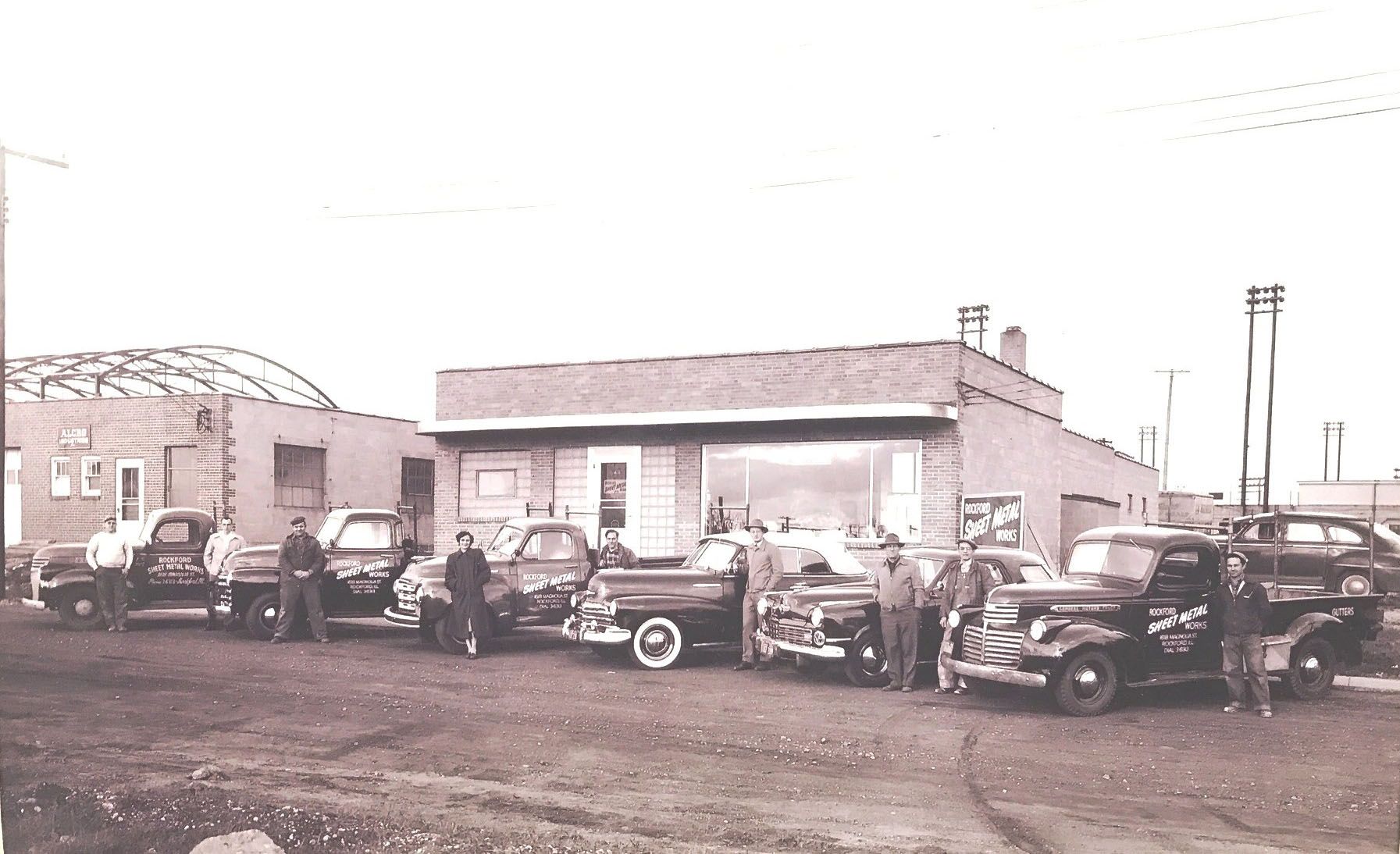 A black and white photo of cars parked 
