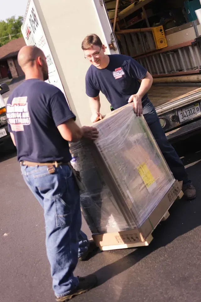 two men are carrying a large box