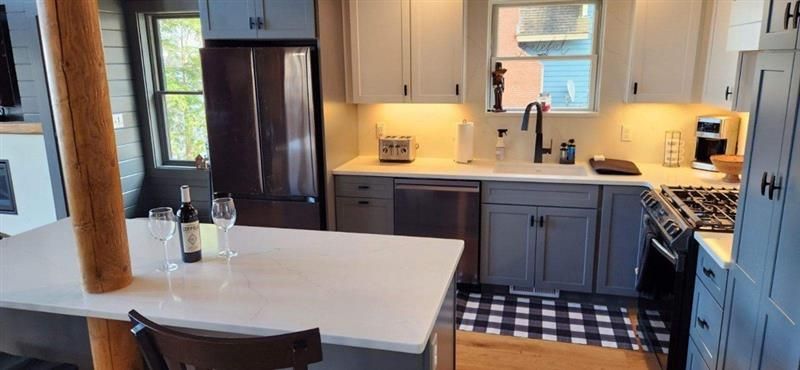 A kitchen with a table and a bottle of wine on it.