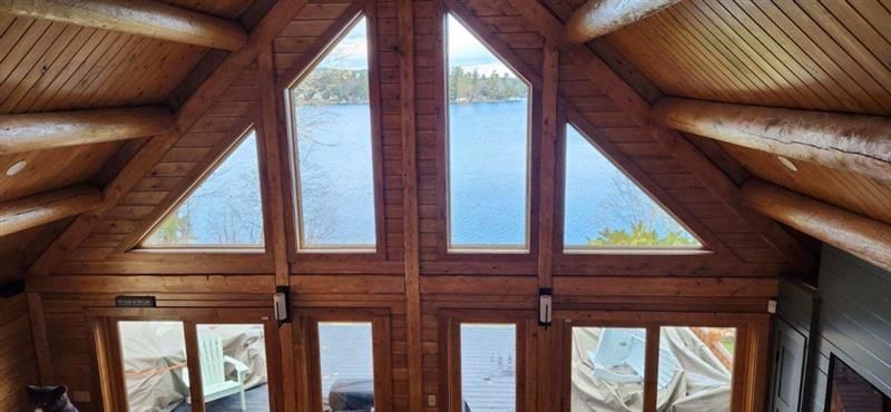 A large wooden house with a lot of windows and a triangle shaped ceiling.