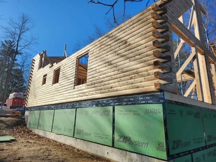 A log cabin is being built in the woods.