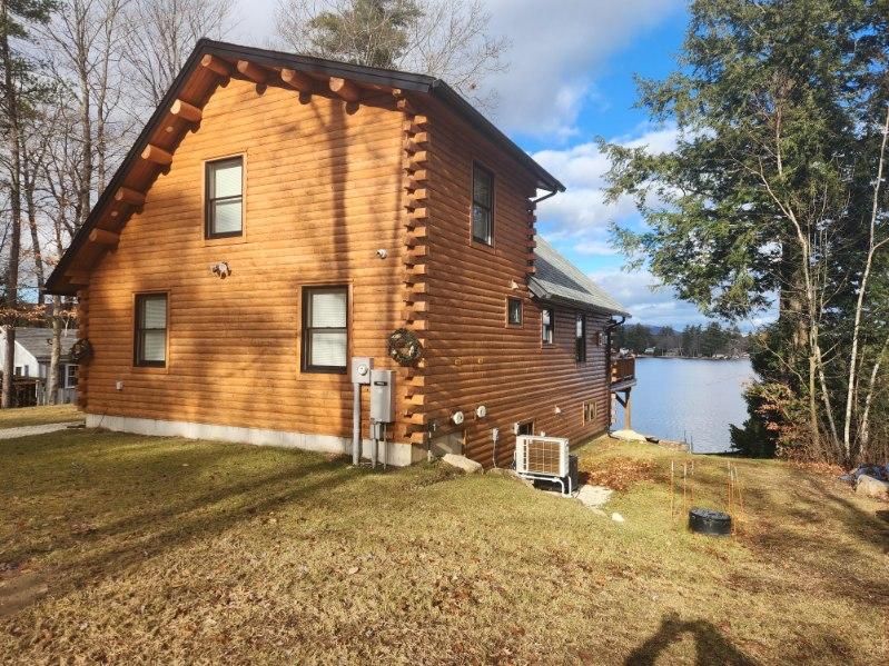 A log cabin is sitting next to a body of water.