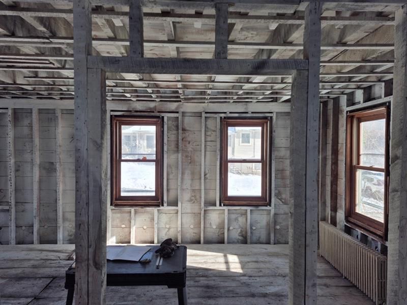 A room with a table and two windows under construction