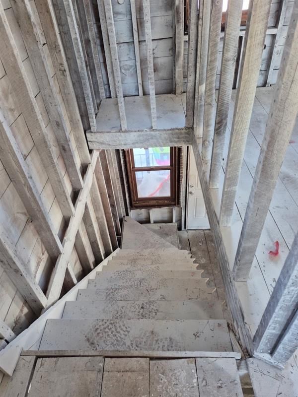 A staircase in a building under construction with a window.