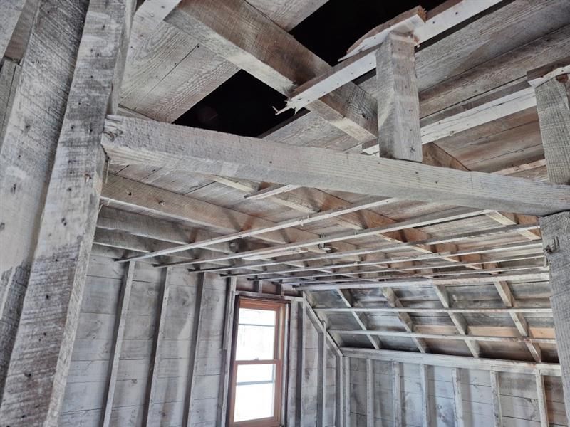 A wooden structure with a window in the middle of it