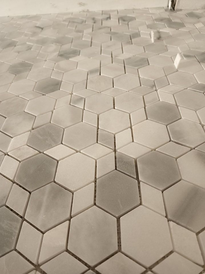 Gray and white hexagon tile floor, geometric pattern.