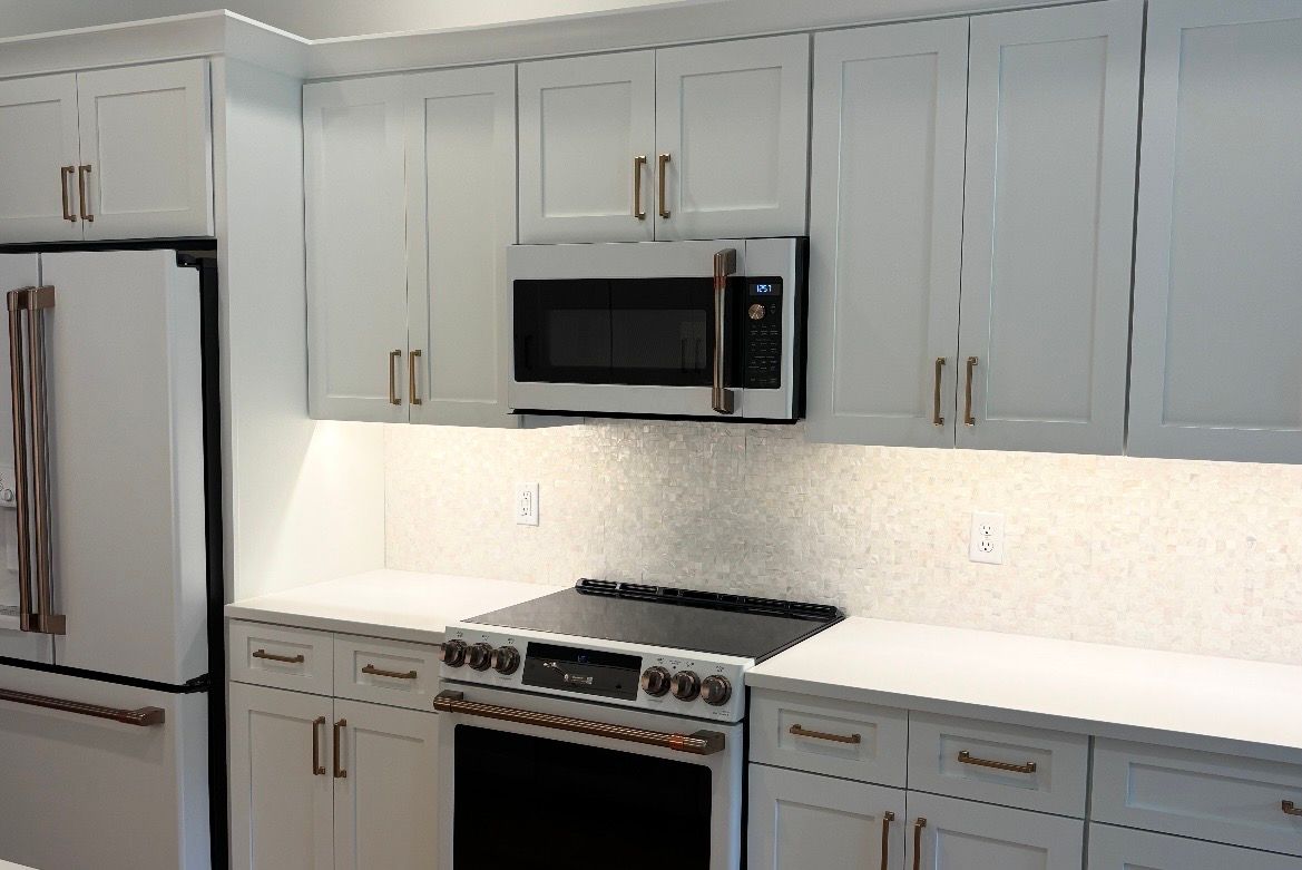 Modern white kitchen with stainless steel appliances and white cabinetry