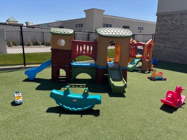 A playground with a slide and a rocking horse