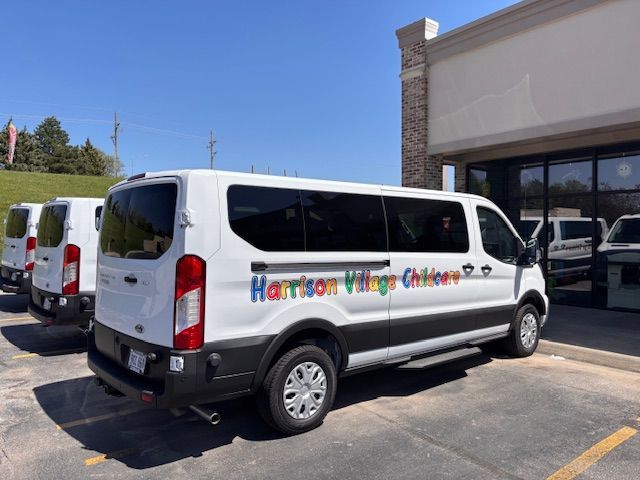 A harrison village children van is parked in a parking lot