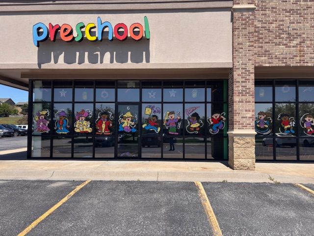 The front of a preschool building with a parking lot in front of it
