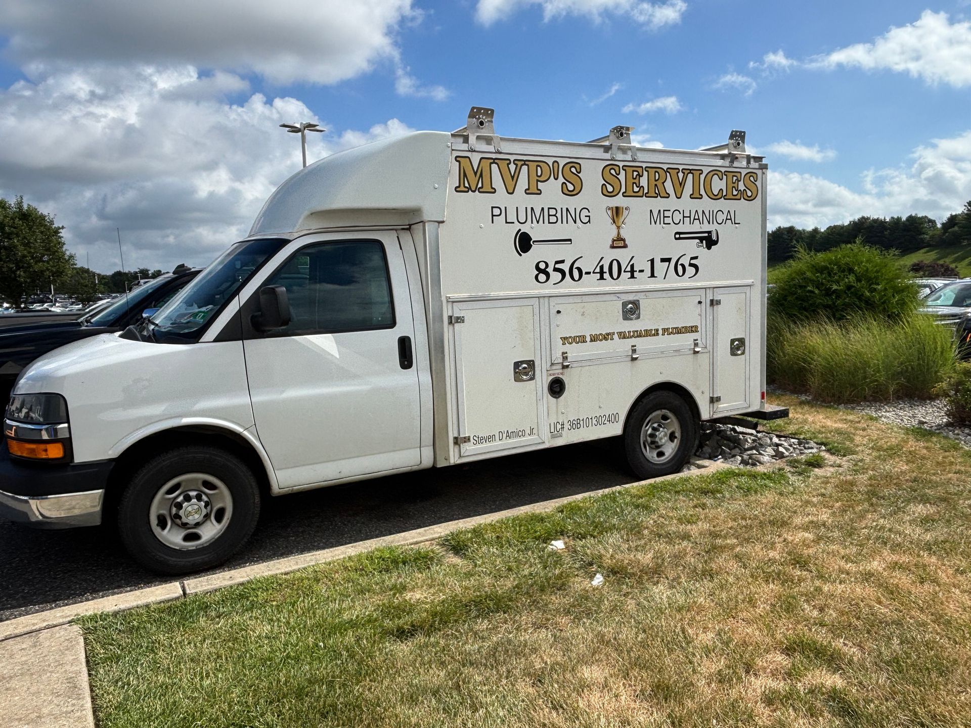 A white service van was parked by the roadside, labeled MVPs Services, under a partly cloudy sky.