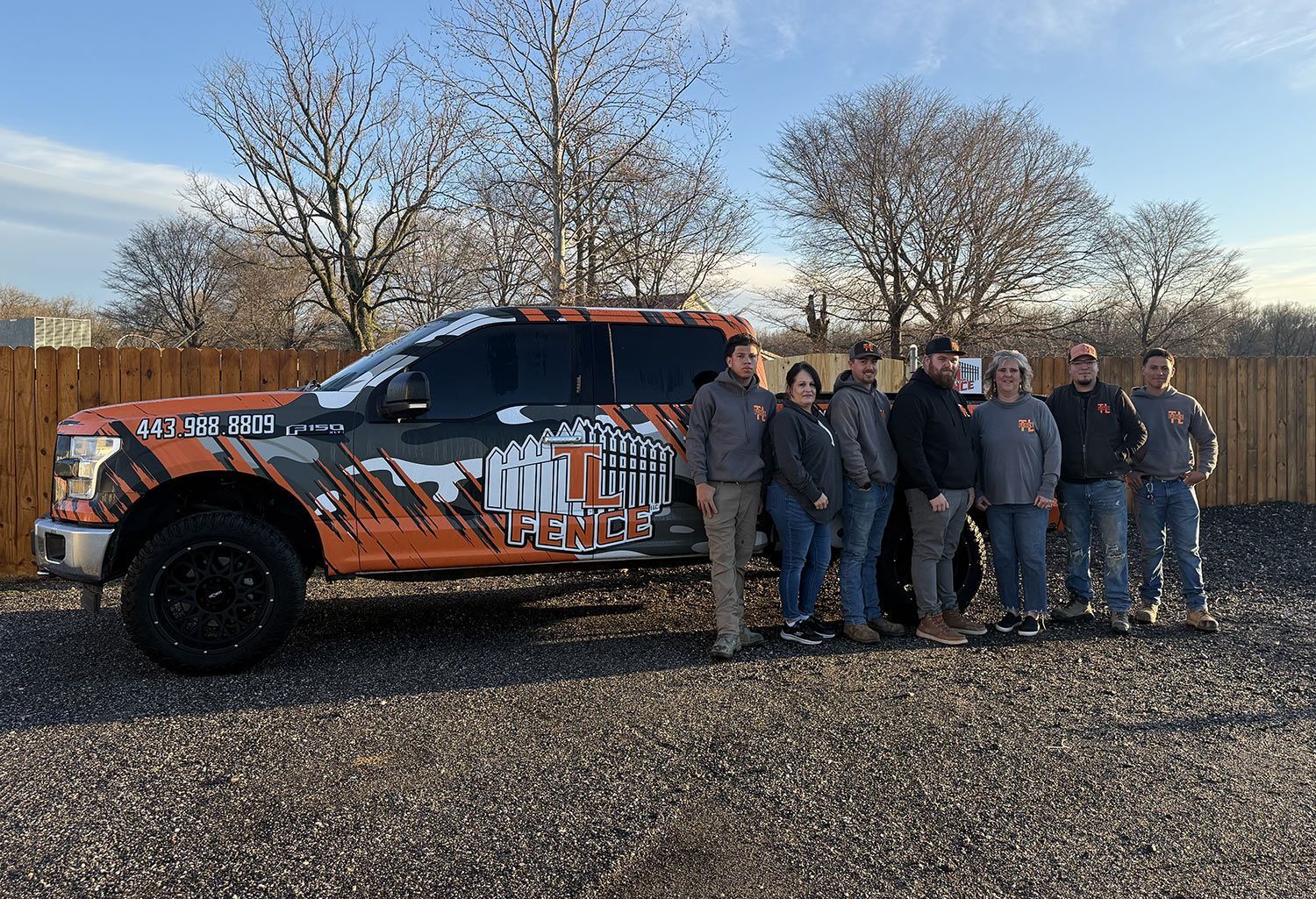 A group of people are standing in front of a truck.