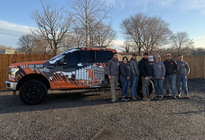 A group of people are standing in front of a truck.