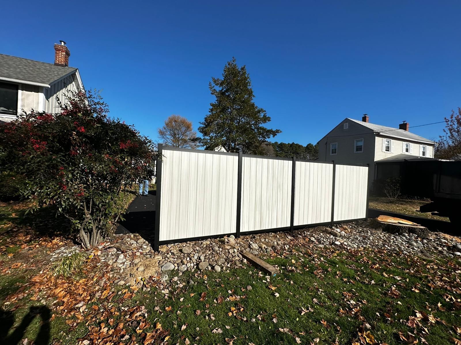 A white fence is sitting in front of a house.